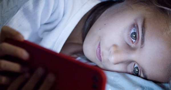 enfant regardant son téléphone le soir