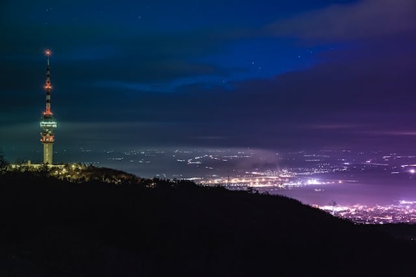Vue d'une ville illuminée depuis une colline dans la nuit