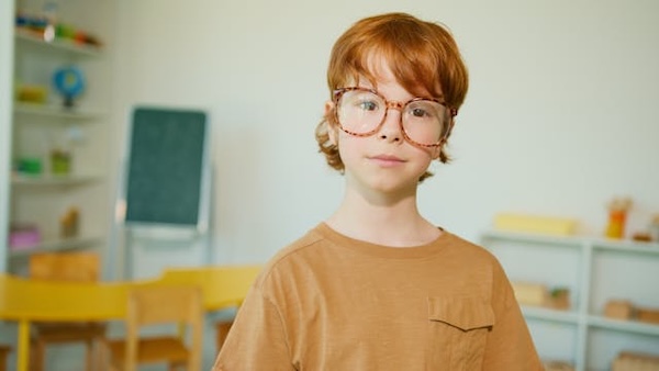 enfant avec des lunettes dans une salle de classe