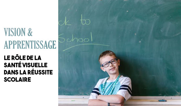 enfant souriant devant un tableau de classe