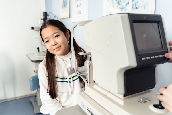 jeune fille souriante passe un examen de la vue