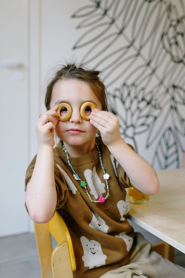 enfant qui met des ronds sur les yeux