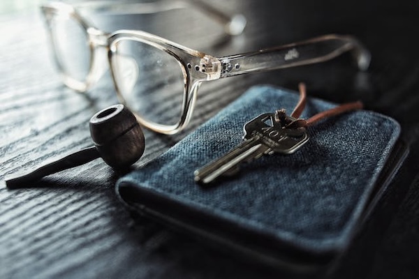 lunettes posée sur une table avec une clef et portefeuille