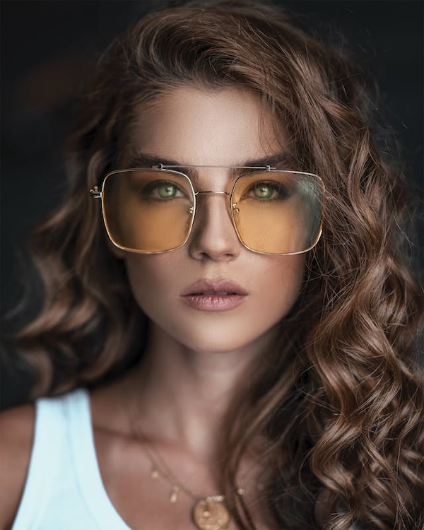 jeune fille en débardeur blanc portant de larges lunettes