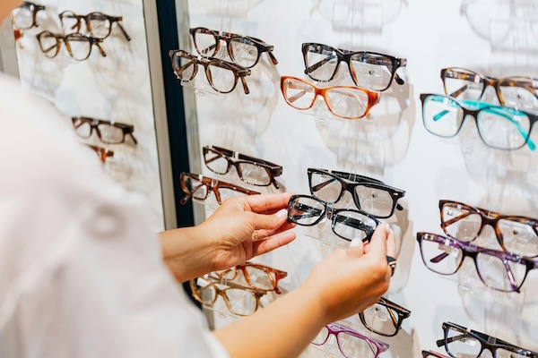 cliente qui sélectionn e une paire de lunettes en magasin