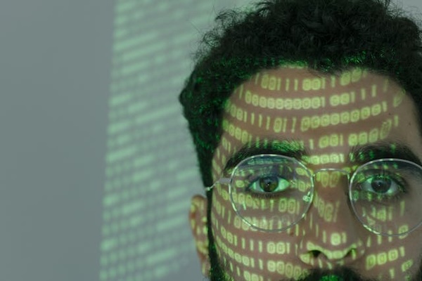 gros plan sur un visage avec des lunettes et des écritures numériques projetées